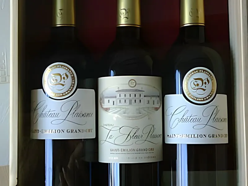 Three dark wine bottles with white and gold labels showing